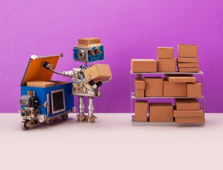 Robot storekeeper uploads craft box parcels into an autonomous delivery robotics courier truck. Automation service of warehousing shipment and distribution concept. Purple gray background